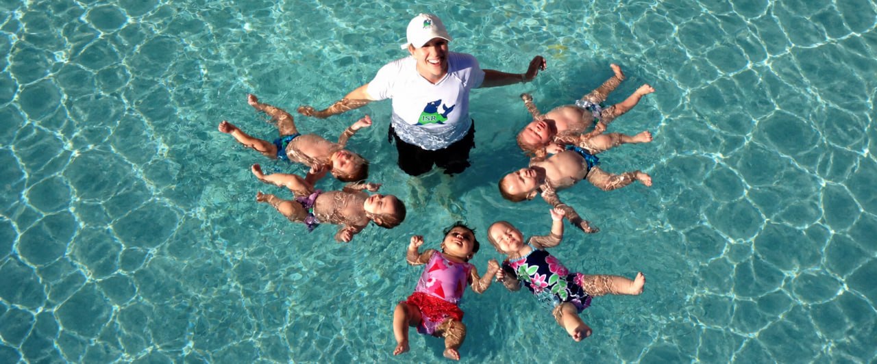 Colleen Haas in the pool with six babies floating safely on their backs during an ISR Self-Rescue lesson