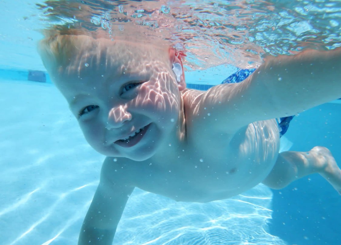 A boy looking up while swimming underwater during an ISR lesson